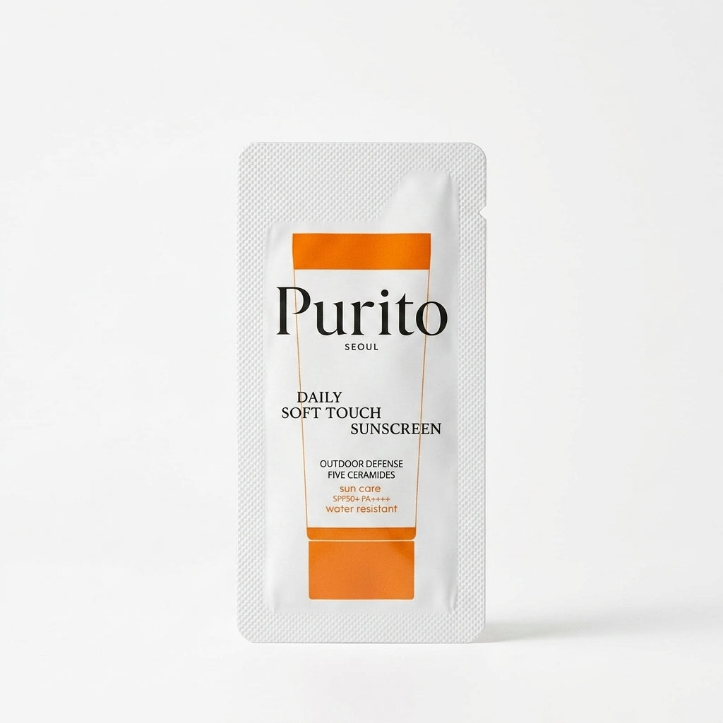 A single-use sunscreen sample sachet from Purito Seoul, featuring a white textured foil pouch with orange accents and black text, set against a clean white background.
